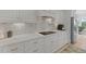 Modern kitchen featuring white cabinetry, a cooktop, and an elegant backsplash at 1216 Rivers Reach Dr, Charleston, SC 29492