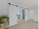 Open-concept living room with a white sliding barn door and light wood flooring at 1216 Rivers Reach Dr, Charleston, SC 29492