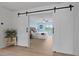Bright and airy main bedroom with a white sliding barn door and light wood flooring at 1216 Rivers Reach Dr, Charleston, SC 29492