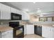 Charming kitchen featuring white cabinets, black appliances, and an opening to the living room at 125 Greyson Cir, Goose Creek, SC 29445