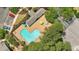 An aerial shot shows a unique pool shape, chairs and tables, surrounded by mature landscaping at 125 Greyson Cir, Goose Creek, SC 29445