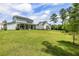 Expansive backyard featuring lush green lawn, mature trees, and a charming two-story home with a covered patio at 125 Integrity Ln, Charleston, SC 29492