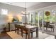 Well-lit dining room with a large sliding glass door, wood table, and decorative chandelier at 125 Integrity Ln, Charleston, SC 29492