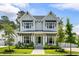 Charming two-story home with a manicured lawn and inviting front porch, complete with lush landscaping at 125 Integrity Ln, Charleston, SC 29492