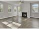 Spacious living room featuring large windows, a ceiling fan, and a cozy fireplace at 125 Integrity Ln, Charleston, SC 29492
