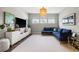 Open-concept living room with a plush blue sectional sofa, a large TV, and neutral décor at 125 Integrity Ln, Charleston, SC 29492