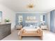 Bright primary bedroom with light blue walls, a bed, a bench, and ample natural light at 125 Integrity Ln, Charleston, SC 29492
