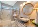 Well-lit bathroom featuring a stone sink, granite countertop, and a shower-tub combo with stylish fixtures at 1308 Divot Ct, Mount Pleasant, SC 29466