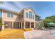 Rear exterior of the house featuring a deck, outdoor living space, and a pool with seating at 1308 Divot Ct, Mount Pleasant, SC 29466