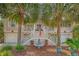 Charming home with palm trees, an American flag, elegant fountain and double staircase leading to the front door at 1308 Divot Ct, Mount Pleasant, SC 29466