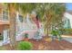Inviting front porch with staircase, a decorative fountain, and lush tropical landscaping at 1308 Divot Ct, Mount Pleasant, SC 29466