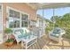 Screened-in porch with wicker furniture, ceiling fan, and view of lush landscaping at 1308 Divot Ct, Mount Pleasant, SC 29466