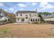A spacious backyard features lush grass, mature trees, a patio area, and a fence for privacy at 1458 Clarendon Way, Mount Pleasant, SC 29466