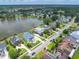 An aerial view of a neighborhood bordering a lake, showcasing well-manicured lawns and mature trees at 1597 Rivertowne Country Club Dr, Mount Pleasant, SC 29466