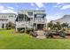 Multi-level backyard featuring an outdoor patio, deck, lush landscaping, and a manicured lawn at 1597 Rivertowne Country Club Dr, Mount Pleasant, SC 29466