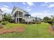 Lush backyard with a manicured lawn, a sprawling deck, and mature trees for added privacy at 1597 Rivertowne Country Club Dr, Mount Pleasant, SC 29466