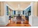 Well-lit dining room with hardwood floors, elegant columns, and views of the outdoors at 1597 Rivertowne Country Club Dr, Mount Pleasant, SC 29466