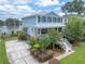 Charming two-story home with a light blue exterior, a spacious front porch, and a well-manicured lawn at 1597 Rivertowne Country Club Dr, Mount Pleasant, SC 29466