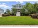 Charming two-story home with a lush front lawn, a grand staircase entrance and mature landscaping at 1597 Rivertowne Country Club Dr, Mount Pleasant, SC 29466