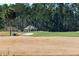 Scenic golf course view features a well-maintained green, sand trap, and a charming clubhouse building surrounded by trees at 1597 Rivertowne Country Club Dr, Mount Pleasant, SC 29466