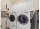 Laundry room featuring a front load washer and dryer, white cabinets, and a utility sink for added convenience at 1597 Rivertowne Country Club Dr, Mount Pleasant, SC 29466