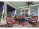 Cozy outdoor porch with comfortable seating, ceiling fan, and charming coastal decor at 1597 Rivertowne Country Club Dr, Mount Pleasant, SC 29466