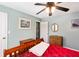Bright bedroom featuring a ceiling fan, light-blue walls, and a red-covered bed with hardwood furnishings at 160 Syrr Run Rd, Saint George, SC 29477