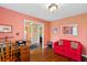 Inviting sitting area with hardwood floors, salmon walls, and a bright red couch at 160 Syrr Run Rd, Saint George, SC 29477