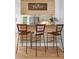 Kitchen bar area with wooden counter and three metal-framed, woven chairs in front of decorative wall at 1604 Macoma Dr, Mount Pleasant, SC 29466