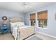 Comfortable bedroom with light blue walls, a light colored bed frame, and two windows with wooded views at 1604 Macoma Dr, Mount Pleasant, SC 29466