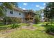 Backyard view of a two-story home with a screened porch and lush landscaping at 1604 Macoma Dr, Mount Pleasant, SC 29466