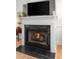 Close up of fireplace with white mantle and black marble hearth featuring a burning fire at 1604 Macoma Dr, Mount Pleasant, SC 29466