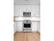 Modern kitchen features stainless steel appliances, white cabinets, granite countertops and wood flooring at 1604 Macoma Dr, Mount Pleasant, SC 29466