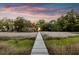 A wooden path stretches toward a waterside home under a colorful sunset sky at 1635 Bull Creek Ln, Charleston, SC 29414