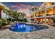 Inviting outdoor living space with a pool, multiple seating areas, and lush tropical landscaping at sunset at 1635 Bull Creek Ln, Charleston, SC 29414