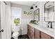 Modern bathroom featuring a dual sink vanity, matte black fixtures, tiled walls and a window for natural light at 1635 Bull Creek Ln, Charleston, SC 29414