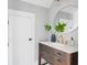 Stylish bathroom featuring wood cabinet, white countertop, round mirror and modern gold faucet at 1635 Bull Creek Ln, Charleston, SC 29414