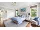 Charming bedroom featuring a queen bed, hardwood floors, and a comfortable accent chair near bright windows at 1635 Bull Creek Ln, Charleston, SC 29414