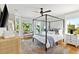 Cozy bedroom features a stylish bed, hardwood floors, bench seating and bright windows in a sun-drenched corner at 1635 Bull Creek Ln, Charleston, SC 29414