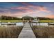 Picturesque dock with a covered seating area extending into a tranquil marsh at sunset at 1635 Bull Creek Ln, Charleston, SC 29414