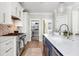 Spacious kitchen with exposed brick, stainless appliances, and a view into the pantry at 1635 Bull Creek Ln, Charleston, SC 29414