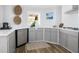 Well-lit kitchen with gray cabinets, stainless steel dishwasher, and marble countertops at 1635 Bull Creek Ln, Charleston, SC 29414