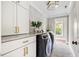 Bright laundry room featuring modern washer and dryer, stylish tile backsplash, and ample counter space at 1635 Bull Creek Ln, Charleston, SC 29414