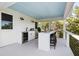 Outdoor bar with wine cooler and seating overlooking the lush trees and greenery, perfect for entertaining at 1635 Bull Creek Ln, Charleston, SC 29414