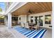 Outdoor dining area with seating for six, complete with an outdoor kitchen and blue striped rug at 1635 Bull Creek Ln, Charleston, SC 29414