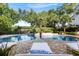 Beautiful pool area with a rock wall, waterfall feature, lounge chairs, and meticulous landscaping at 1635 Bull Creek Ln, Charleston, SC 29414
