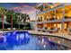 Inviting pool area with lounge chairs, lush landscaping, and a multi-story house in the background at dusk at 1635 Bull Creek Ln, Charleston, SC 29414