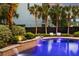 Beautiful backyard swimming pool with retaining wall waterfall feature surrounded by tropical landscaping at 1635 Bull Creek Ln, Charleston, SC 29414