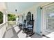 Inviting front porch featuring rocking chairs, white railing and supports, and a painted ceiling at 1635 Bull Creek Ln, Charleston, SC 29414