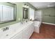 Primary bath featuring a double vanity, large mirrors, and a separate bathtub and shower at 1648 Secessionville Rd, Charleston, SC 29412
